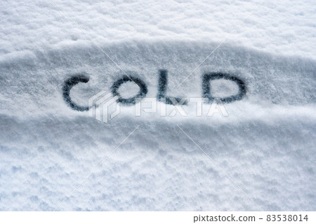 Written white snow cold weather concept. Written word COLD symbol. Snowy winter cold temperature background. Below zero forecast snow concept. Winter cover snow weather conditions. Bad weather warning 83538014