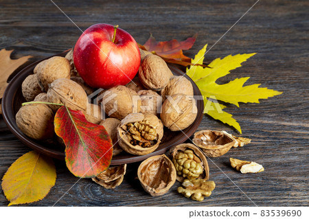 Autumn still life with walnuts and apple. Autumn still life with walnuts and apple. 83539690
