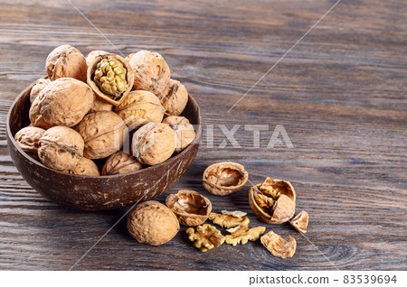 Walnuts on a brown wooden background Walnuts on a brown wooden background 83539694