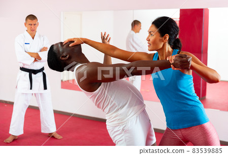 Self-defense lesson - woman strikes painful blow in eyes of man Self-defense lesson - woman strikes painful blow in eyes of man 83539885