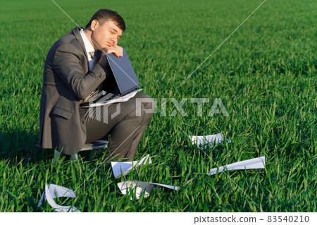 businessman works in a green field, freelance and business concept, green grass and blue sky as background 83540210