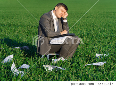 businessman works in a green field, freelance and business concept, green grass and blue sky as background businessman works in a green field, freelance and business concept, green grass and blue sky as background 83540217