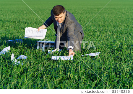 businessman works in a green field, freelance and business concept, green grass and blue sky as background businessman works in a green field, freelance and business concept, green grass and blue sky as background 83540226