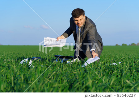 businessman works in a green field, freelance and business concept, green grass and blue sky as background 83540227