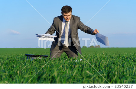 businessman works in a green field, freelance and business concept, green grass and blue sky as background businessman works in a green field, freelance and business concept, green grass and blue sky as background 83540237