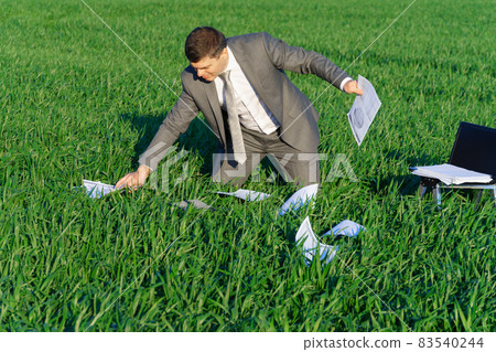 businessman works in a green field, freelance and business concept, green grass and blue sky as background 83540244