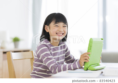 Girl elementary school student studying on a tablet PC 83540423