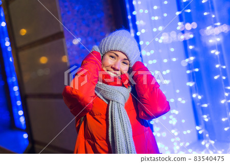 Winter holiday season. Christmas, New Year concept. Funny happy woman spend time having fun near illuminated and decorated showcase on city street. Winter holiday season. Christmas, New Year concept. Funny happy woman spend time having fun near illuminated and decorated showcase on city street. 83540475
