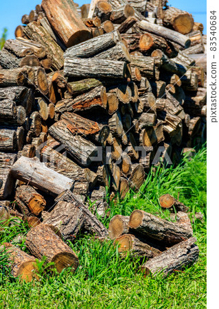 Pile of firewood on a green lawn at backyard Pile of firewood on a green lawn at backyard 83540684