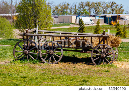 Old wooden cart with hay at farmyard Old wooden cart with hay at farmyard 83540690