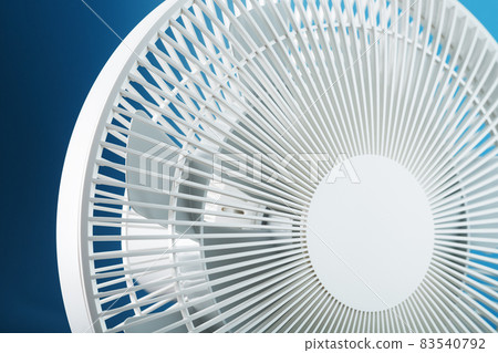 The grille and blades of the electric fan are white on a blue background The grille and blades of the electric fan are white on a blue background 83540792