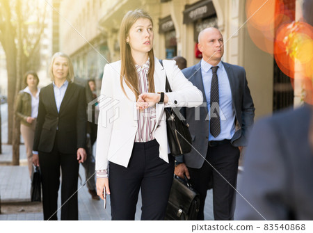 Portrait of hurrying woman among passers 83540868