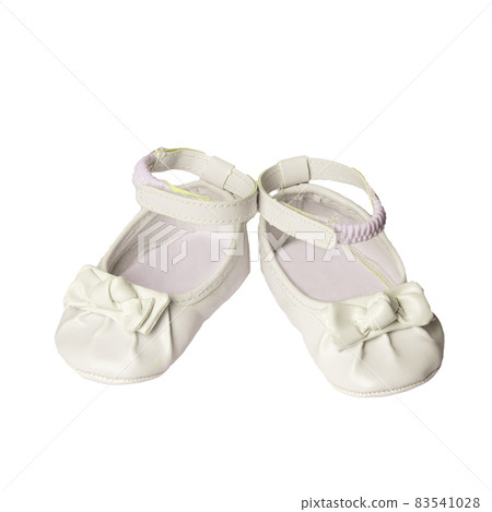White shoes for a little girl with leather bows on a white background. Children's shoes 83541028