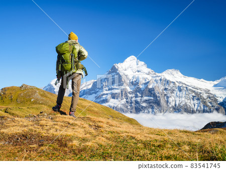 Tourist with a backpack in the mountains. Mountain hiking in the high mountains.  83541745