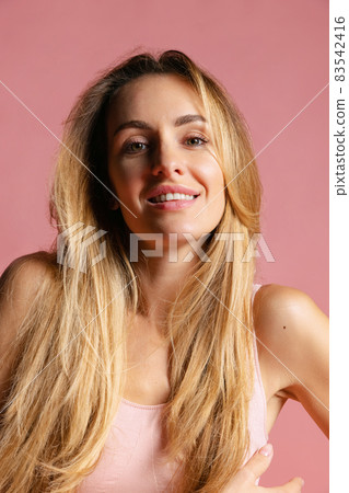 Close-up portrait of young beautiful girl without makeup isolated over pink studio background. Natural beauty concept. Close-up portrait of young beautiful girl without makeup isolated over pink studio background. Natural beauty concept. 83542416