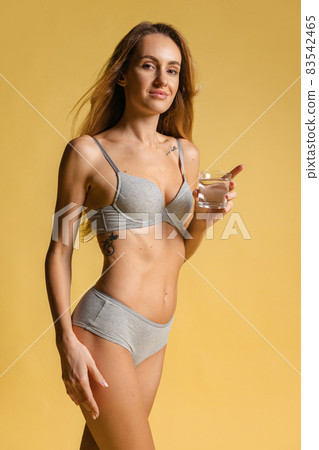 Half-length portrait of young beautiful slim woman in underwear, bra and panties isolated over light background. Natural beauty concept. Half-length portrait of young beautiful slim woman in underwear, bra and panties isolated over light background. Natural beauty concept. 83542465