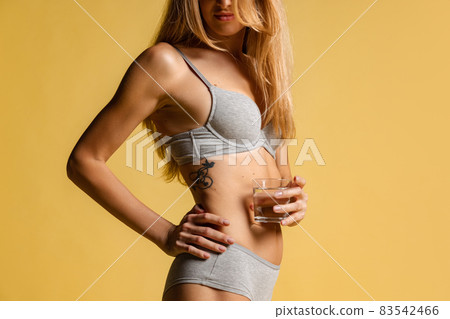 Half-length portrait of young beautiful slim woman in underwear, bra and panties isolated over light background. Natural beauty concept. Half-length portrait of young beautiful slim woman in underwear, bra and panties isolated over light background. Natural beauty concept. 83542466