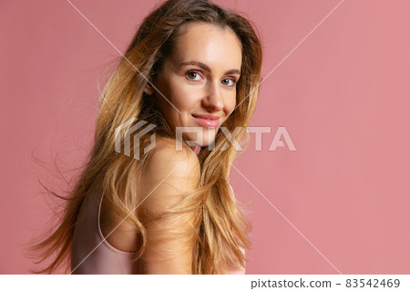 Close-up portrait of young beautiful girl without makeup isolated over pink studio background. Natural beauty concept. Close-up portrait of young beautiful girl without makeup isolated over pink studio background. Natural beauty concept. 83542469
