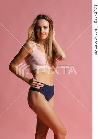 Portrait of young beautiful slim woman in lingerie posing isolated over pink studio background. Natural beauty concept. Portrait of young beautiful slim woman in lingerie posing isolated over pink studio background. Natural beauty concept. 83542472