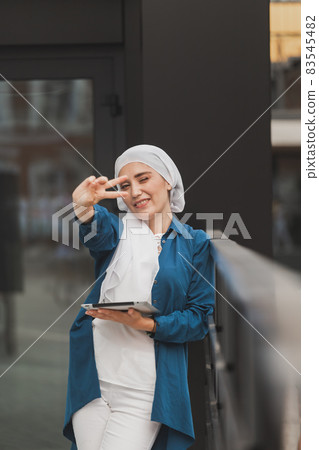 Smiling asian girl student professional employee holding tablet and sit at outdoor park, happy woman studying e learning online software using technology app for work education 83545482