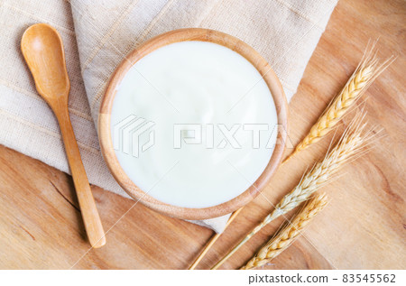 Greek yogurt in a wooden bowl and dry barley. Greek yogurt in a wooden bowl and dry barley. 83545562