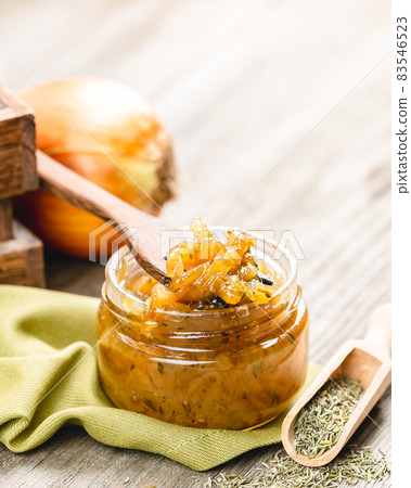 Onion jam in a glass jar on a wooden table 83546523