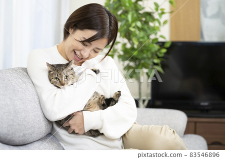 Woman with a cat in the living room Woman with a cat in the living room 83546896
