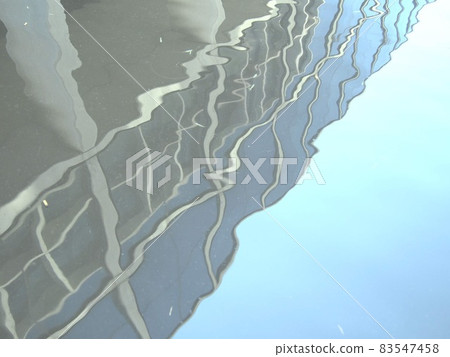 Concrete building and sky reflected on the surface of the water Concrete building and sky reflected on the surface of the water 83547458