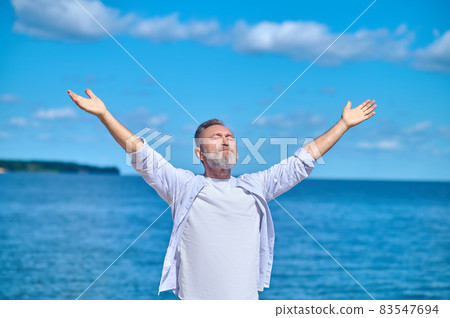 Man with arms outstretched to sides Man with arms outstretched to sides 83547694
