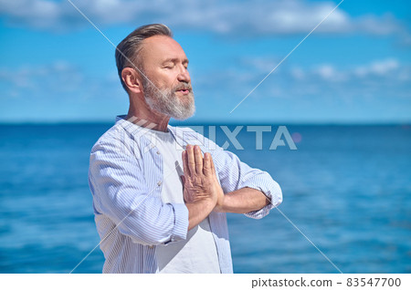 Calm man in namaste pose outdoors Calm man in namaste pose outdoors 83547700