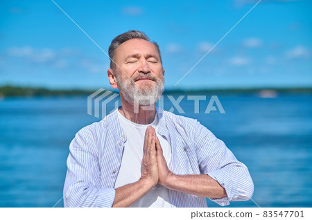 Man with closed eyes meditating in nature Man with closed eyes meditating in nature 83547701