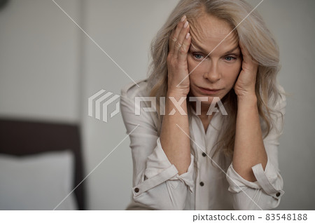 Despondent blonde mature woman suffering from loneliness 83548188