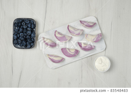 Top view of frozen vareniki with blueberry and sour cream 83548483