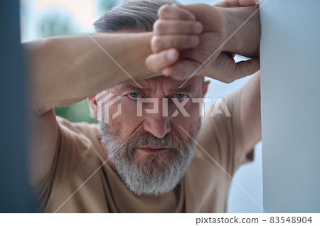 Gloomy blue-eyed Caucasian man pondering over something Gloomy blue-eyed Caucasian man pondering over something 83548904