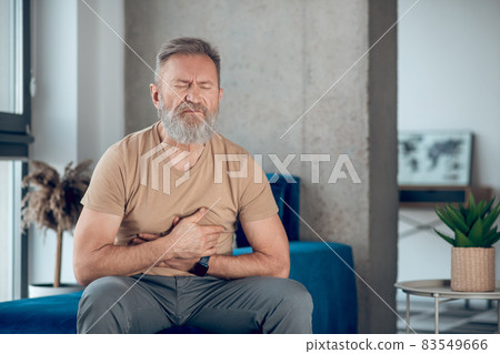 A mature man suffering from a stomach ache A mature man suffering from a stomach ache 83549666