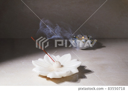 Smoke from burning incense sticks standing on lotus incense holder Smoke from burning incense sticks standing on lotus incense holder 83550718