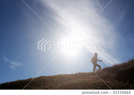 Young woman hiker with a backpack on the top of the mountain Young woman hiker with a backpack on the top of the mountain 83550868