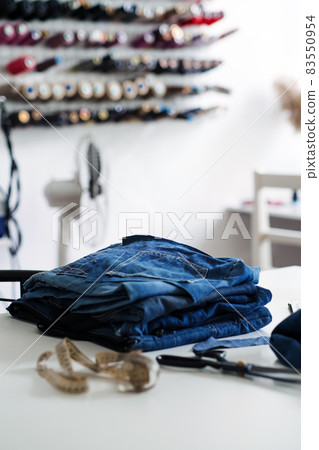 Denim Upcycling Ideas, Using Old Jeans, Repurposing Jeans, Reusing Old Jeans, Upcycle Stuff. Stack of old blue jeans, scissors, thread and sewing tools in sewing studio. Selective focus Denim Upcycling Ideas, Using Old Jeans, Repurposing Jeans, Reusing Old Jeans, Upcycle Stuff. Stack of old blue jeans, scissors, thread and sewing tools in sewing studio. Selective focus 83550954