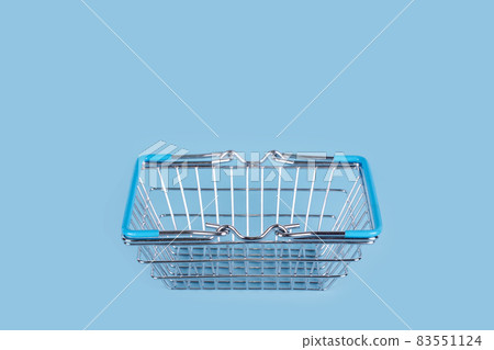 Supermarket shopping basket on light blue background. Empty metal wire basket. Black friday, sale, shopping concept. Sustainable lifestyle. Free space for text Supermarket shopping basket on light blue background. Empty metal wire basket. Black friday, sale, shopping concept. Sustainable lifestyle. Free space for text 83551124