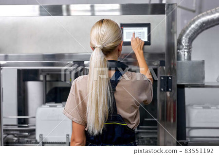 experienced factory worker turn on the robotic line for pesticides bottling and packing 83551192