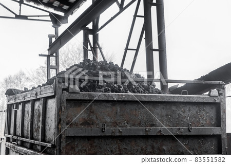 A pile of coking coal in the back of a dump truck. Industrial cargo transportation and transport industy of minerals 83551582