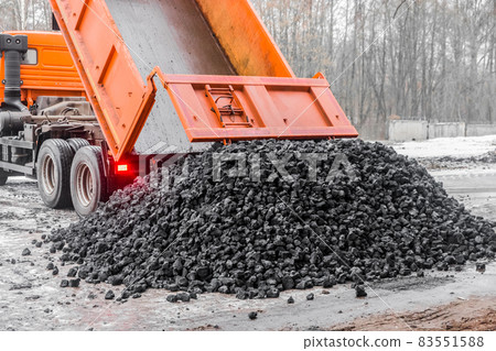 Dump truck in the industrial zone unloads coking coal from the body Dump truck in the industrial zone unloads coking coal from the body 83551588
