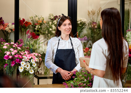 Side View On Young Friendly Woman Florist Having Talk With Customer Client In Shop Side View On Young Friendly Woman Florist Having Talk With Customer Client In Shop 83552244
