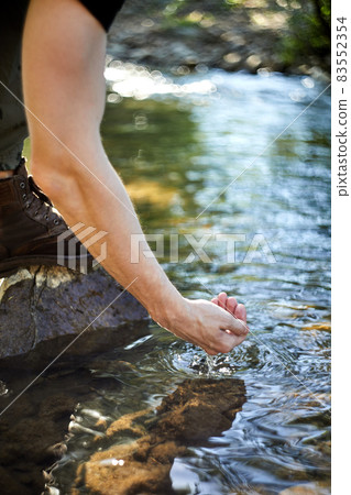 Man taking pure water from river, closeup, side view. Nature healing power 83552354