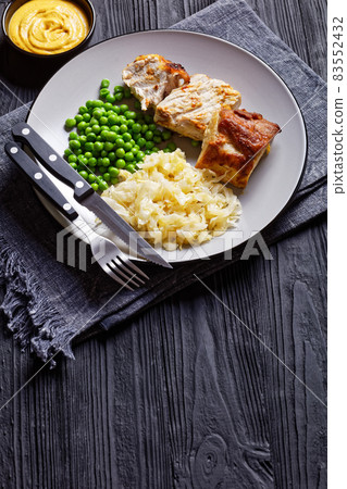 Pork loin and sauerkraut on a plate, close-up 83552432