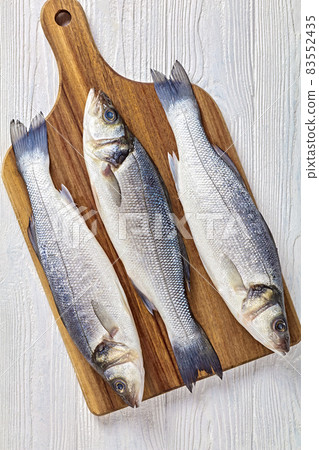 Raw sea bass on a table, top view, close-up 83552435