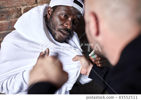 Hooligan robs african man. Caucasian guy is threatening frightened black man Hooligan robs african man. Caucasian guy is threatening frightened black man 83552511
