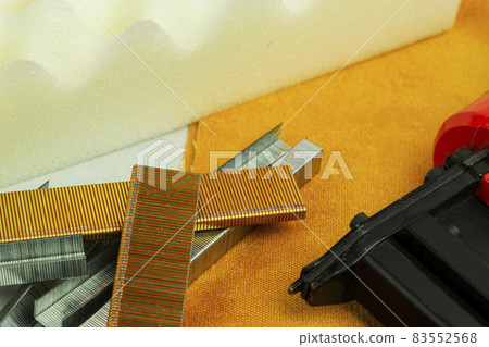 a piece of foam rubber and a stapler for clogging staples, upholstered furniture production. a piece of foam rubber and a stapler for clogging staples, upholstered furniture production. 83552568