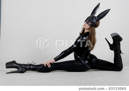 Sexy beautiful woman pole dancer posing in latex costume on background. Easter bunny concept. 83553069