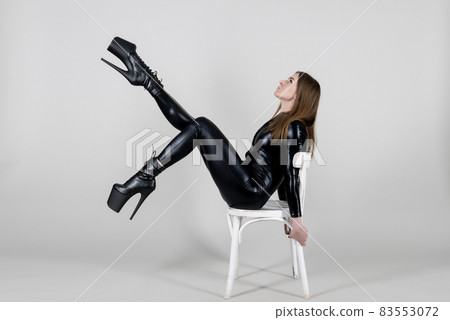 Sexy beautiful woman pole dancer posing in latex costume on background. 83553072